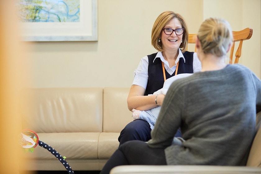 St John of God Burwood Hospital Social Worker smiling and talking with mother and infant in the Mother and Baby Unit