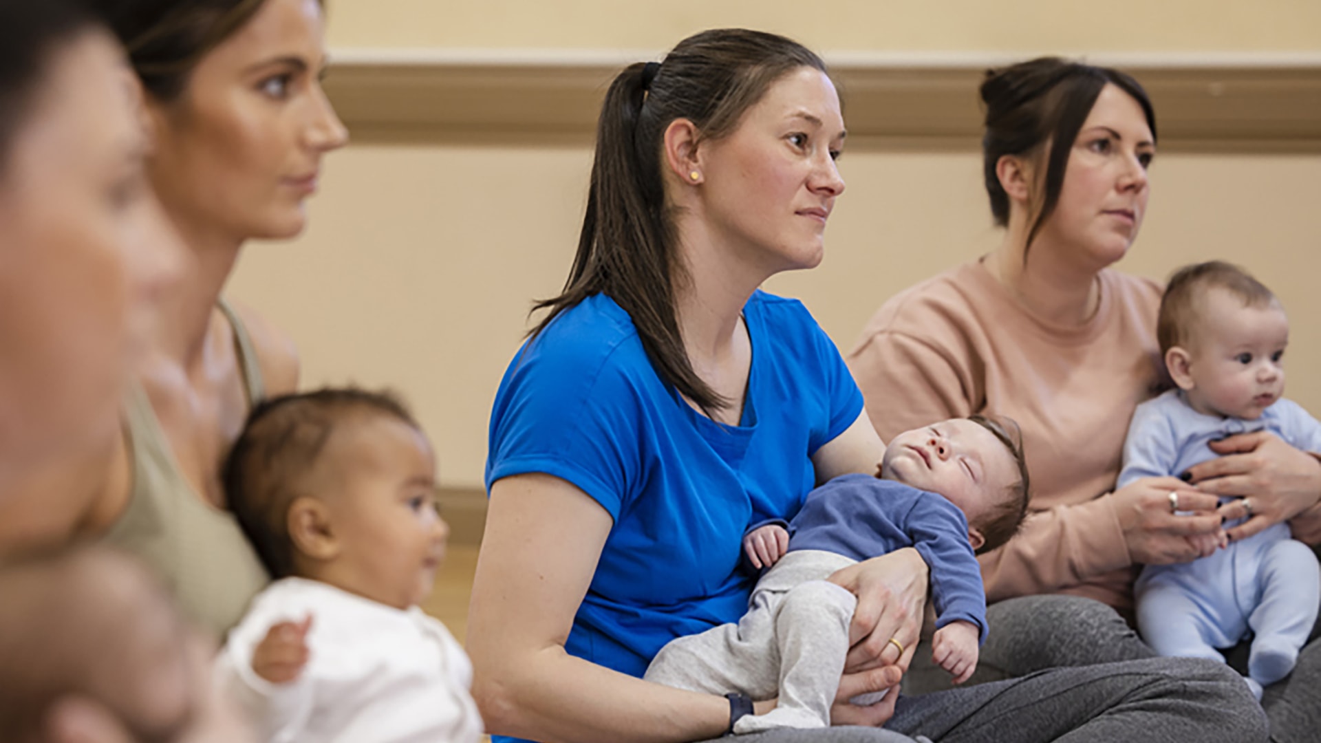 Group of mothers sitting with infants in their laps