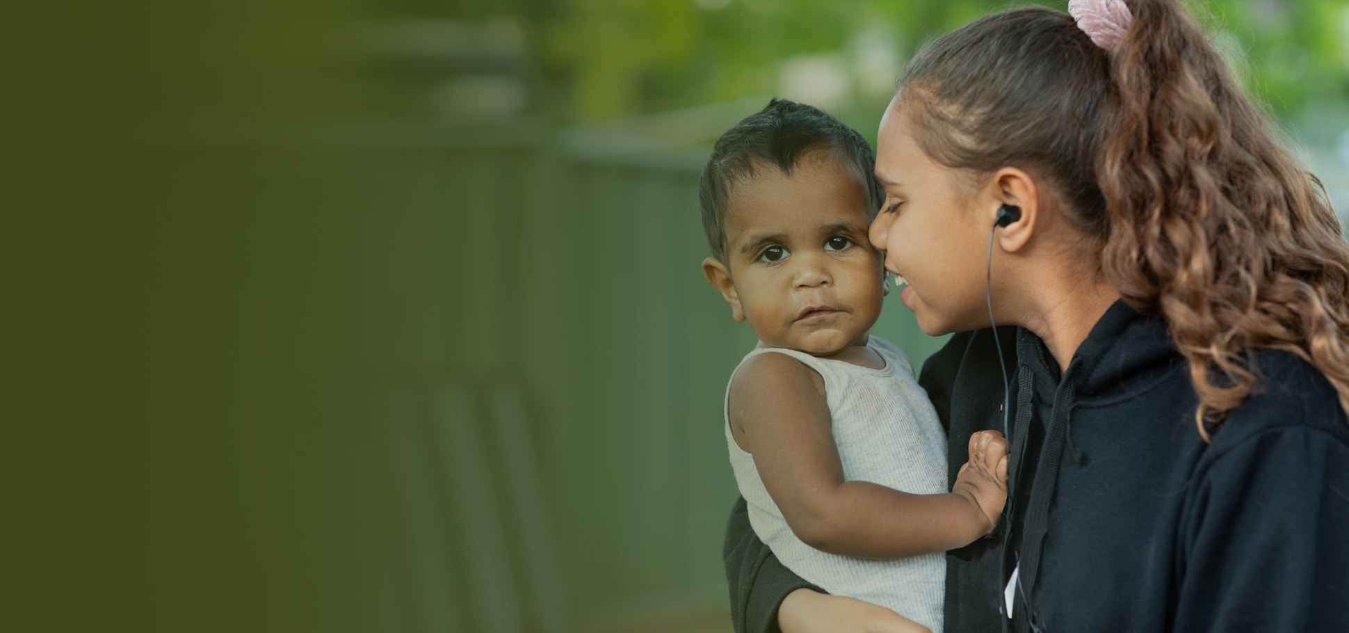 Indigenous mother holding infant outdoors